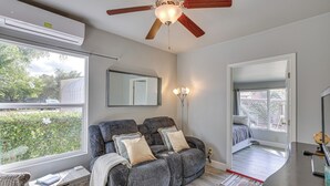 A modern living room with a grey sofa, a ceiling fan, a large window, and a view of the outdoors. - 2 Mi to Dtwn Atascadero! Cozy Cottage w/ Yard (Atascadero)