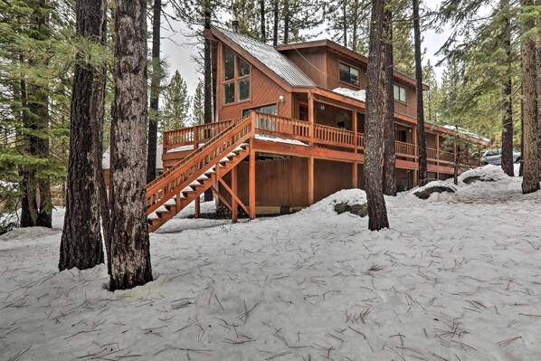 A wooden cabin with a staircase leading to a deck, surrounded by tall pine trees and snow. - Truckee Winter Escape 6 Mi to Ski Slopes! (Truckee)