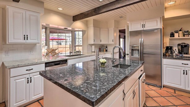 A modern kitchen with white cabinetry, a granite countertop, and a stainless steel refrigerator. - Hot Tub & Fire Pit: Sedona Oasis! (Sedona)