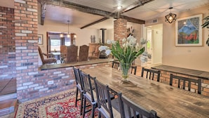 A dining area with a wooden table, chairs, and a brick fireplace. - Hot Tub & Fire Pit: Sedona Oasis! (Sedona)