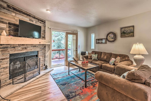 A living room with a fireplace, a television, a sofa, and a coffee table. - Mountain Lodge w/ Hot Tub, Walk to Grindstone Lake (Ruidoso)