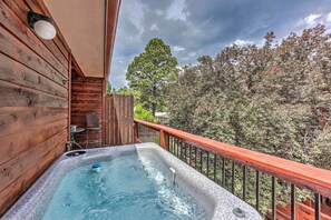 A hot tub on a wooden deck with a view of trees and a cloudy sky. - Mountain Lodge w/ Hot Tub, Walk to Grindstone Lake (Ruidoso)