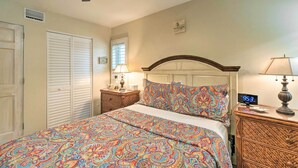 A bedroom with a bed, two bedside tables, a ceiling fan, and a window with blinds. - Longboat Key Condo W/lanai, Walk to Beach & Shops (Longboat Key)