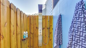 A wooden fence, a metal shower enclosure, and a towel hanging on a wall. - Charming Vacation Rental: Close to Downtown! (Sarasota)