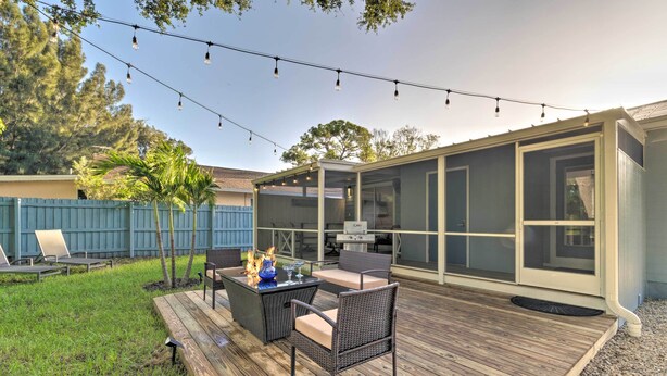 An outdoor deck with a fire pit, seating, and string lights. - Charming Vacation Rental: Close to Downtown! (Sarasota)