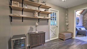A room with wooden shelves, a cabinet, and a door leading to another room.