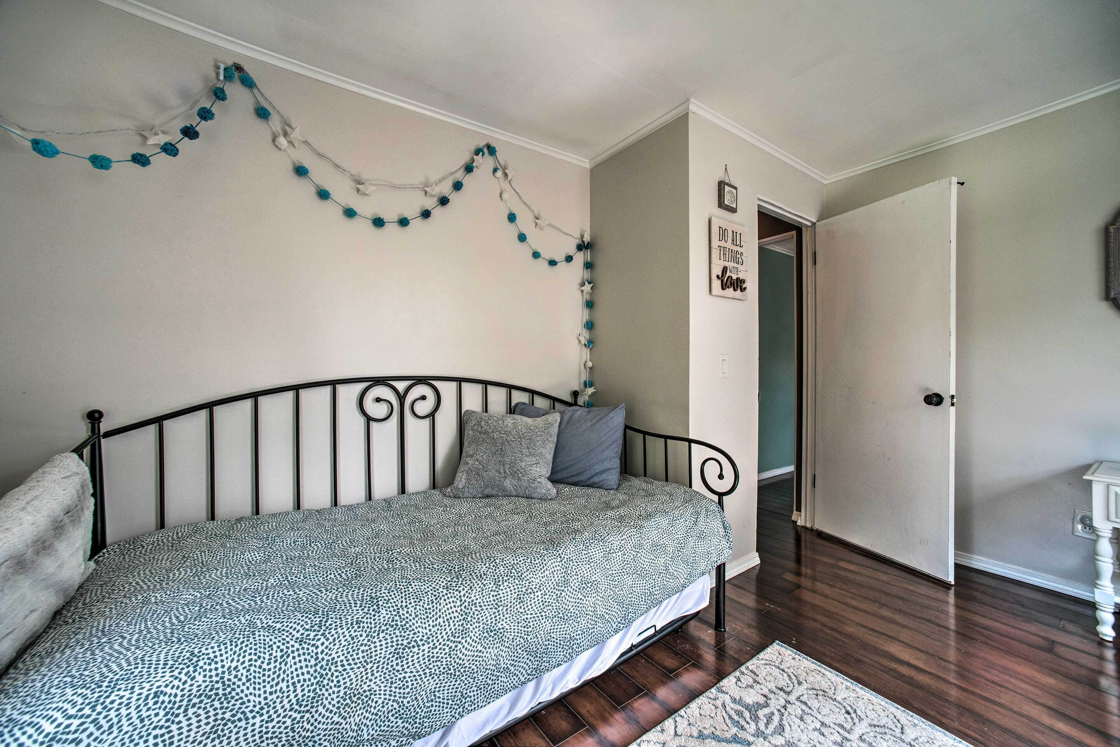 Un dormitorio con cama, una puerta y un adorno en la pared.