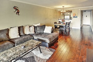 A living room with a sectional sofa, a coffee table, and a dining area with a table and chairs. - < 1 Mi to Old Town! Couples Haven w/ Pool Access (Scottsdale)