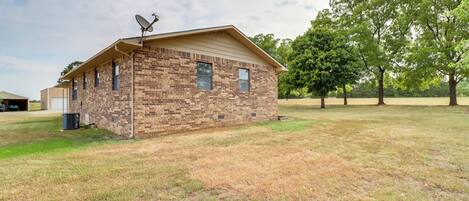 A single-story brick building with a sloped roof and satellite dish.