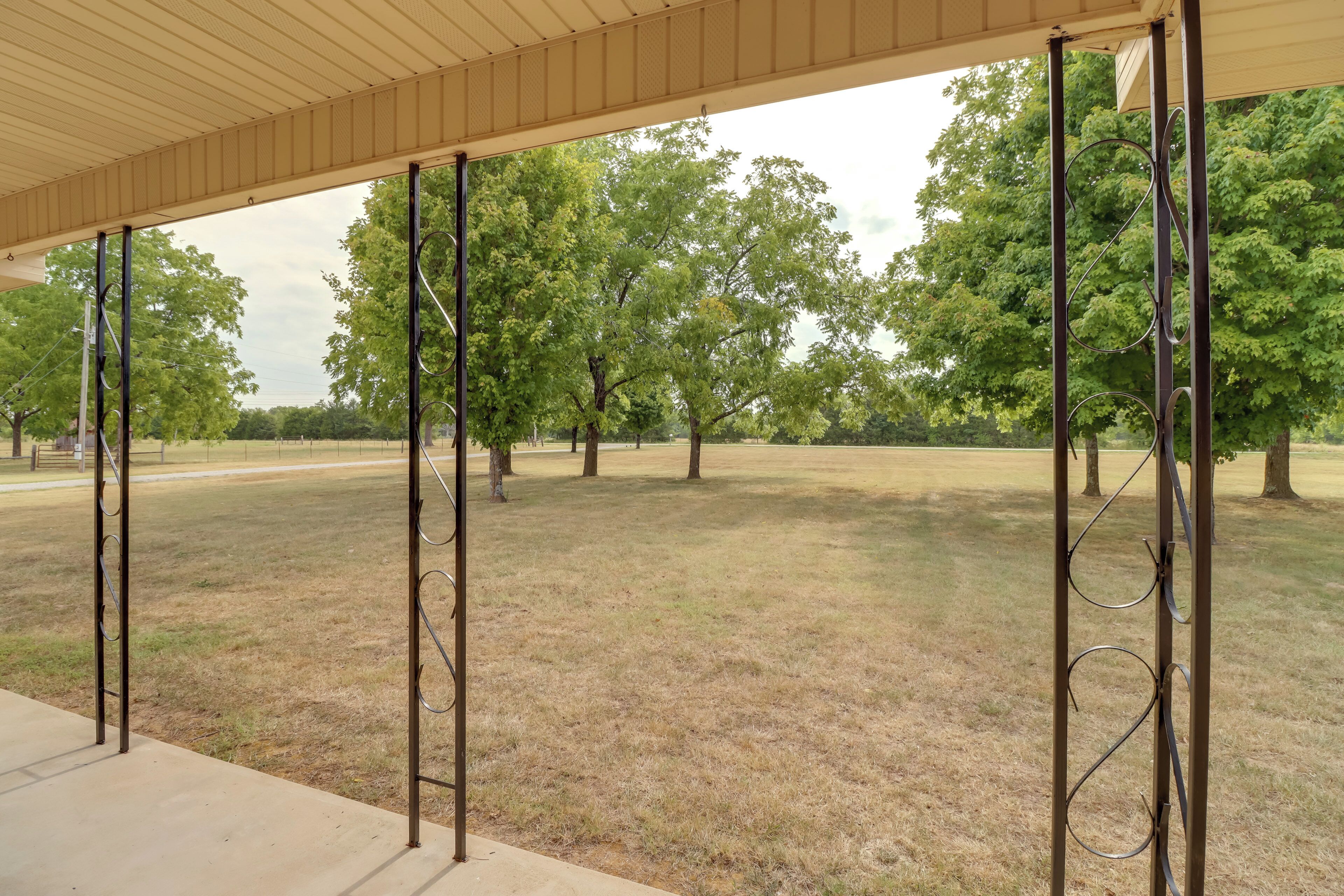 A covered outdoor area with metal structures and trees in the background.