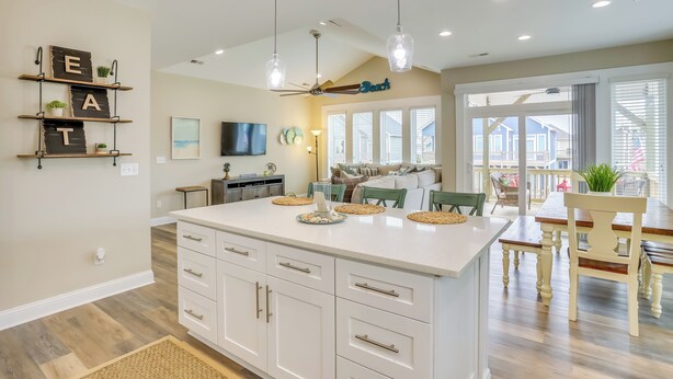 A spacious kitchen with a large island, pendant lights, and a ceiling fan. - Surf City Home w/ Outdoor Shower: Walk to Beach! (Holly Ridge)