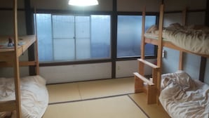 Un dormitorio con literas, un escritorio y un ventanal con vidrio esmerilado.