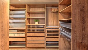 Ein Holzschnellschrank mit mehreren Einlegeböden und Schubladen, einer Kleiderstange und einer Deckenleuchte.