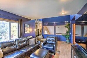 A modern living room with a leather sofa, a leather armchair, and a potted plant. - Puget Sound Home w/ Beautiful Yard & Deck! (Des Moines)