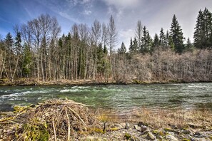 A river with a rocky foreground and a forest in the background.