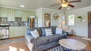 A modern kitchen with a built-in oven, a refrigerator, and a dining area with a sofa and a coffee table.