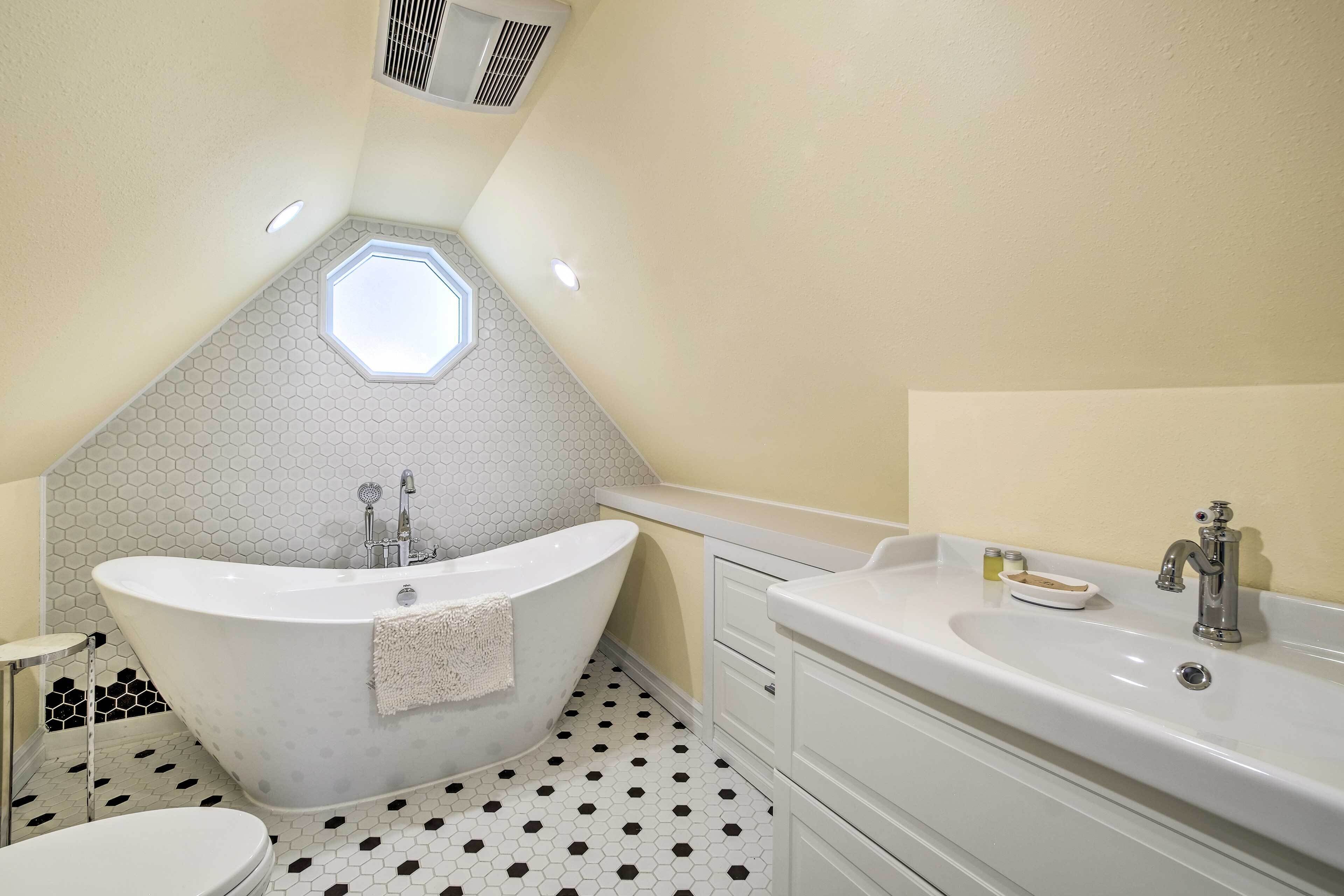 Une salle de bain moderne avec une baignoire sur pieds, un meuble-lavabo et des toilettes.