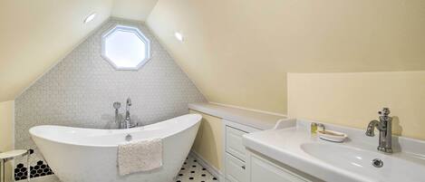 A modern bathroom with a freestanding bathtub, a vanity with a sink, and a toilet.