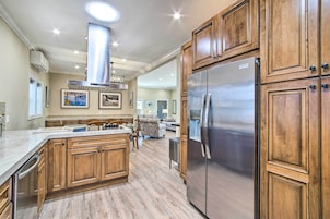 Una cocina con armarios de madera, un refrigerador de acero inoxidable y una isla central.