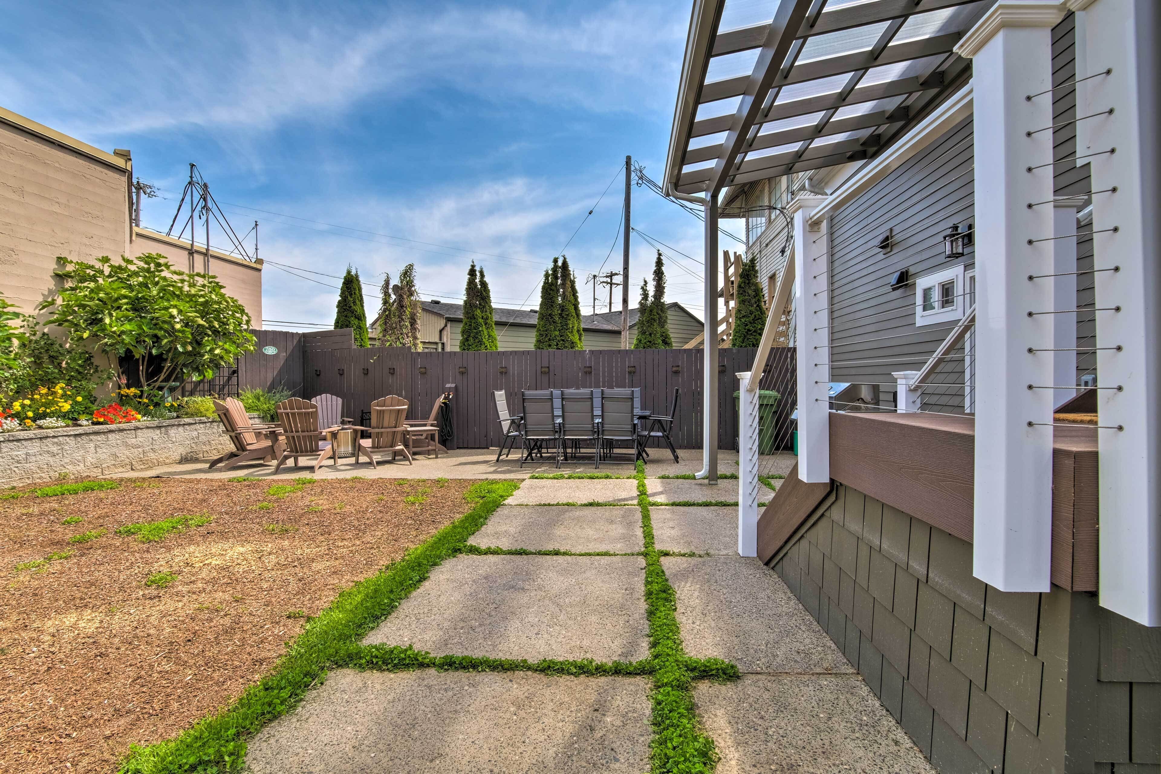 A backyard with a patio, outdoor furniture, and a pergola.