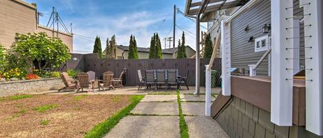A backyard with a patio, outdoor furniture, and a pergola.