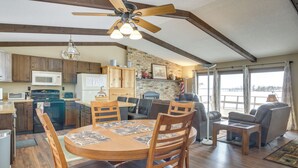 A spacious living area with a dining table, wooden chairs, a sofa, and a ceiling fan. - Breezy Point House w/ Dock on Pelican Lake! (Pequot Lakes)