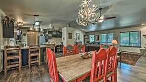 A spacious kitchen with a wooden dining table and chairs, a chandelier, and a ceiling fan. - Wooded Ruidoso Hideaway w/ Deck: Ski, Hike & Golf! (Ruidoso)