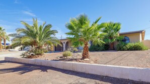 A residential area with palm trees, a driveway, and a building with a garage. - 5 Mi to Lake Havasu: Home w/ Yard & Pool (Lake Havasu City)
