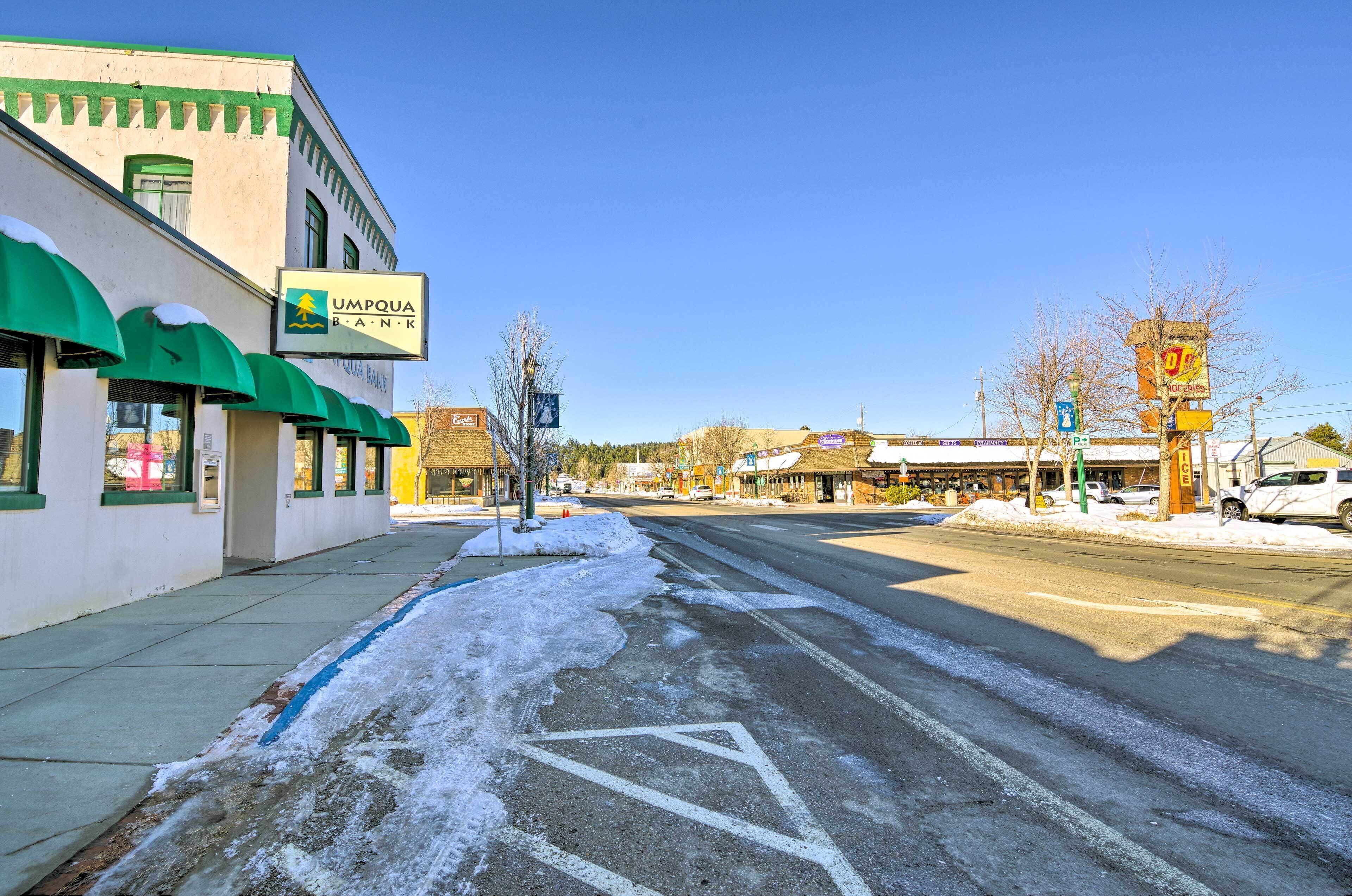A street with a bank and a building with a green awning.