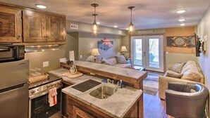 A modern kitchen with wooden cabinets, stainless steel appliances, and pendant lighting. - Deck, Lake Views! Group Getaway in Osage Beach (Osage Beach)