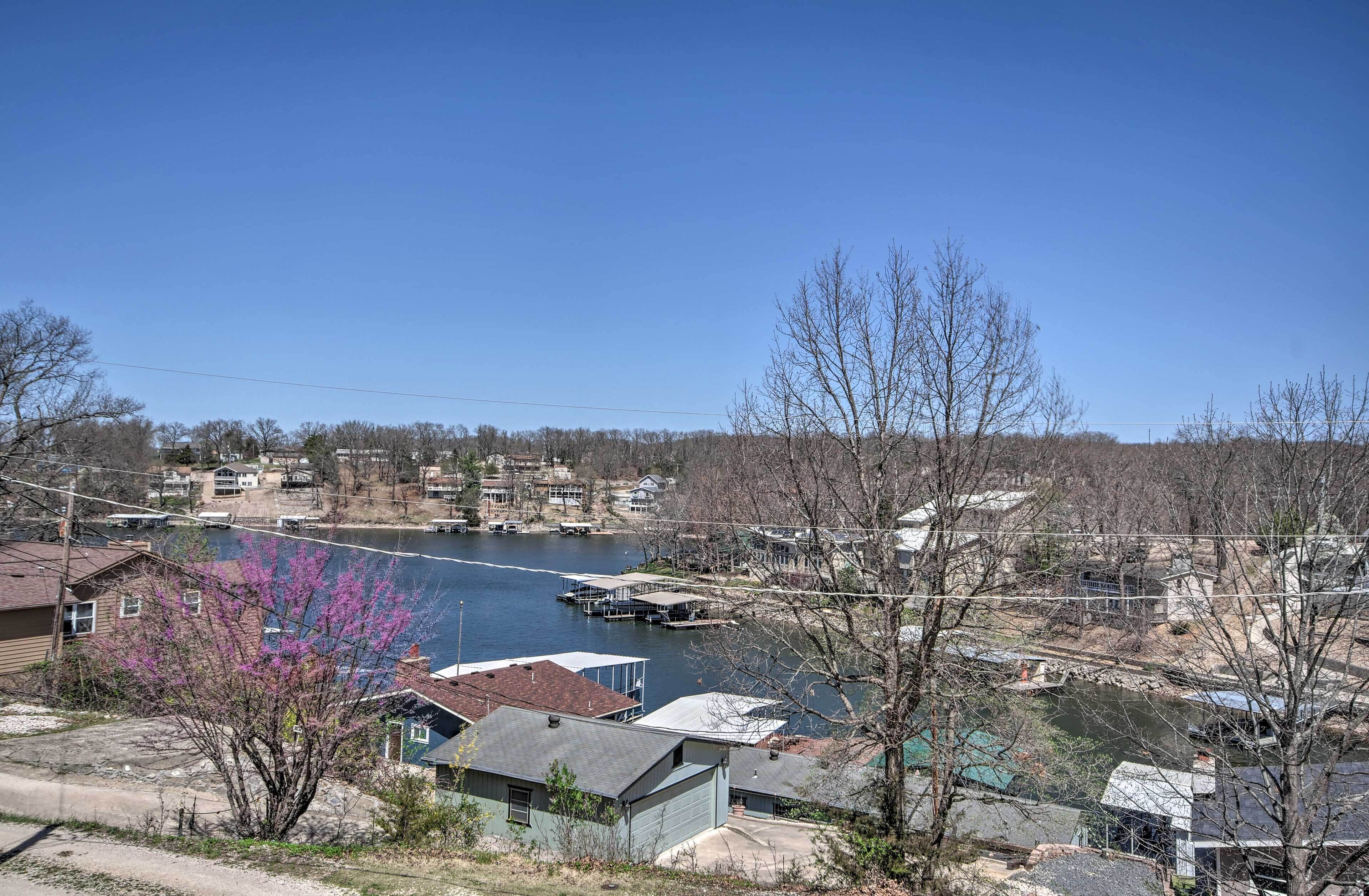 A residential area with houses along a river, docks, and a clear blue sky.