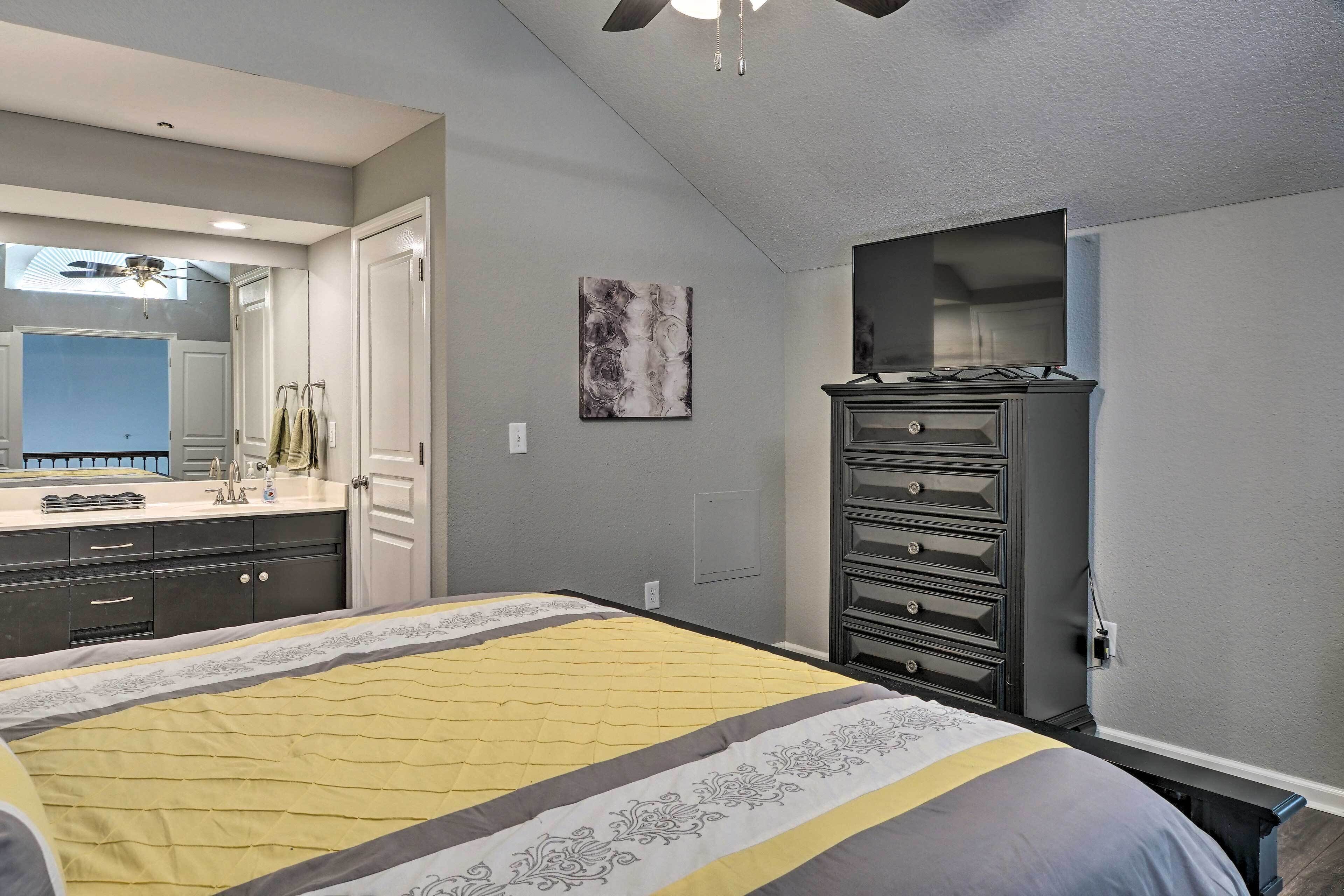 A bedroom with a bed, dresser, and a TV.