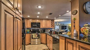A modern kitchen with wooden cabinets, stainless steel appliances, and a large island.
