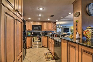 Una cucina moderna con mobili in legno, elettrodomestici in acciaio inossidabile e una grande isola.