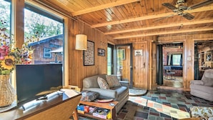 A wooden cabin interior with a sofa, television, and a dining area. - Cabin on Rush Lake w/ Bar, Grill & Kayaks! (Atlanta)