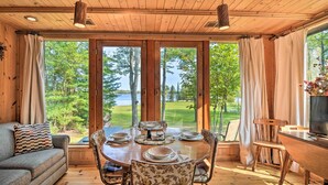 A wooden cabin with a dining area, a sofa, and a TV. - Cabin on Rush Lake w/ Bar, Grill & Kayaks! (Atlanta)