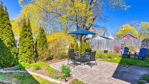 A patio with a table and chairs, surrounded by a wooden fence and trees. - Mystic Refuge w/ Patio < 1 Mi to Downtown! (Mystic)