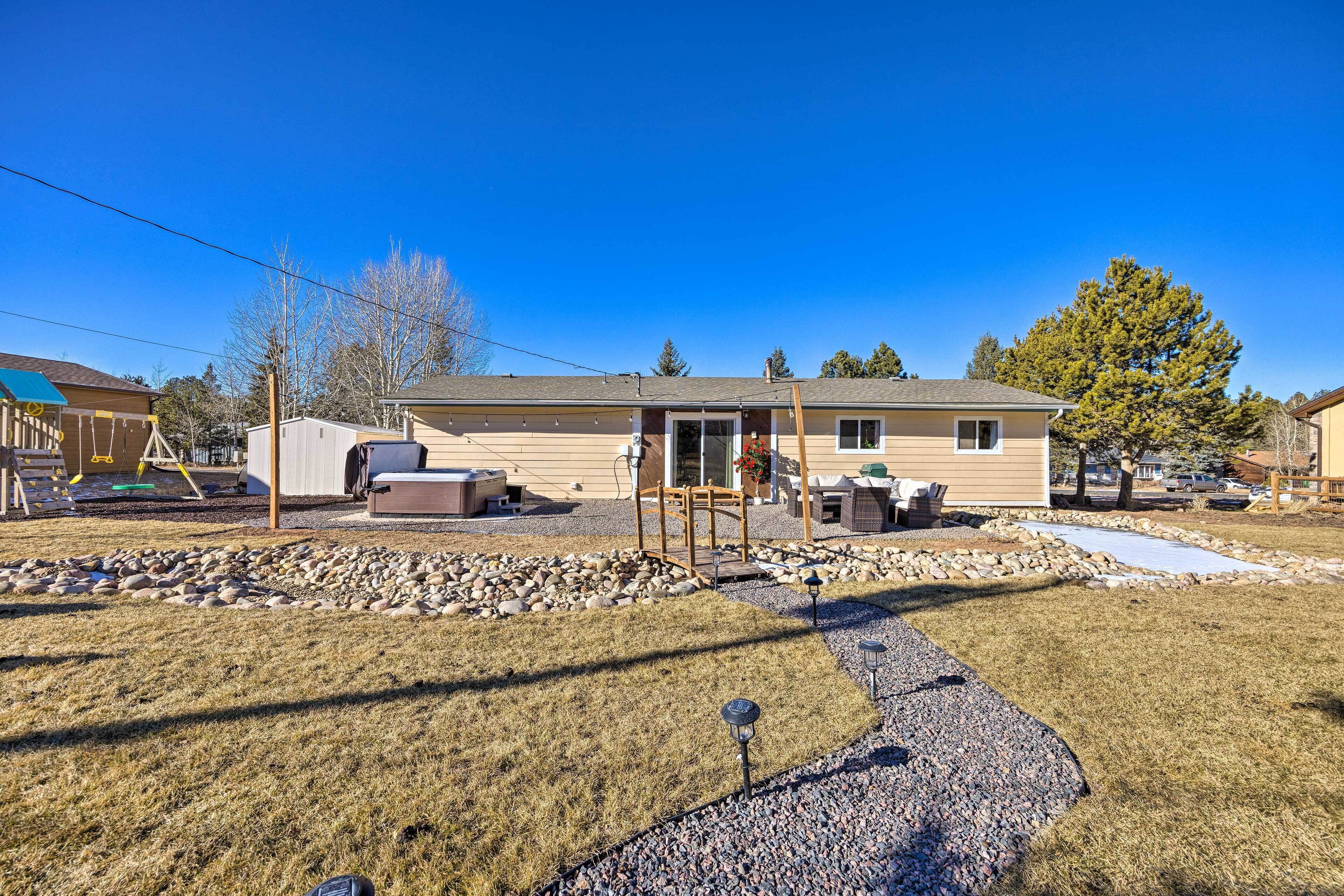 A single-story house with a covered porch, a small deck, and a gravel driveway.