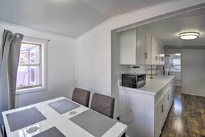 A compact kitchen with white cabinets, a microwave, and a small island.