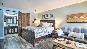 A bedroom with a bed, a sofa, a desk, and a sliding door closet. - Ski-in/ski-out Getaway at Boyne Mountain Resort (Boyne Falls)
