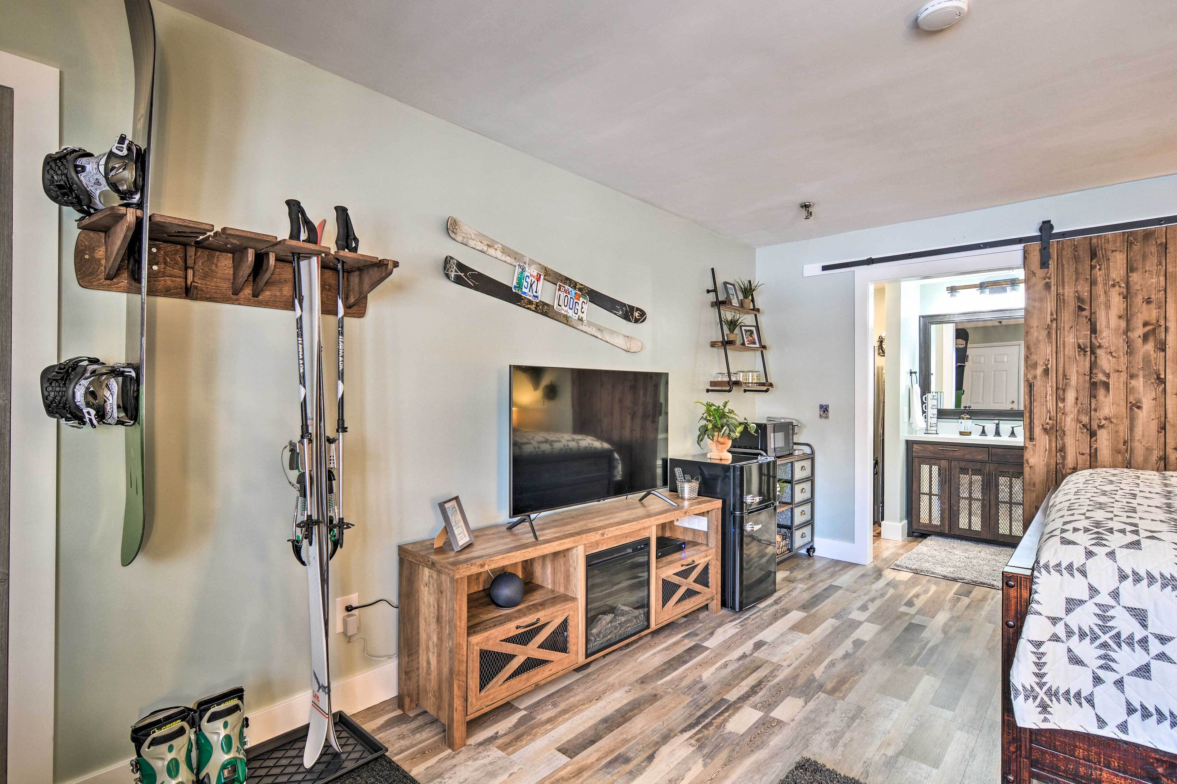 Ein modernes Wohnzimmer mit einer Holzeinbauwand, Skiern und einem Fernseher.