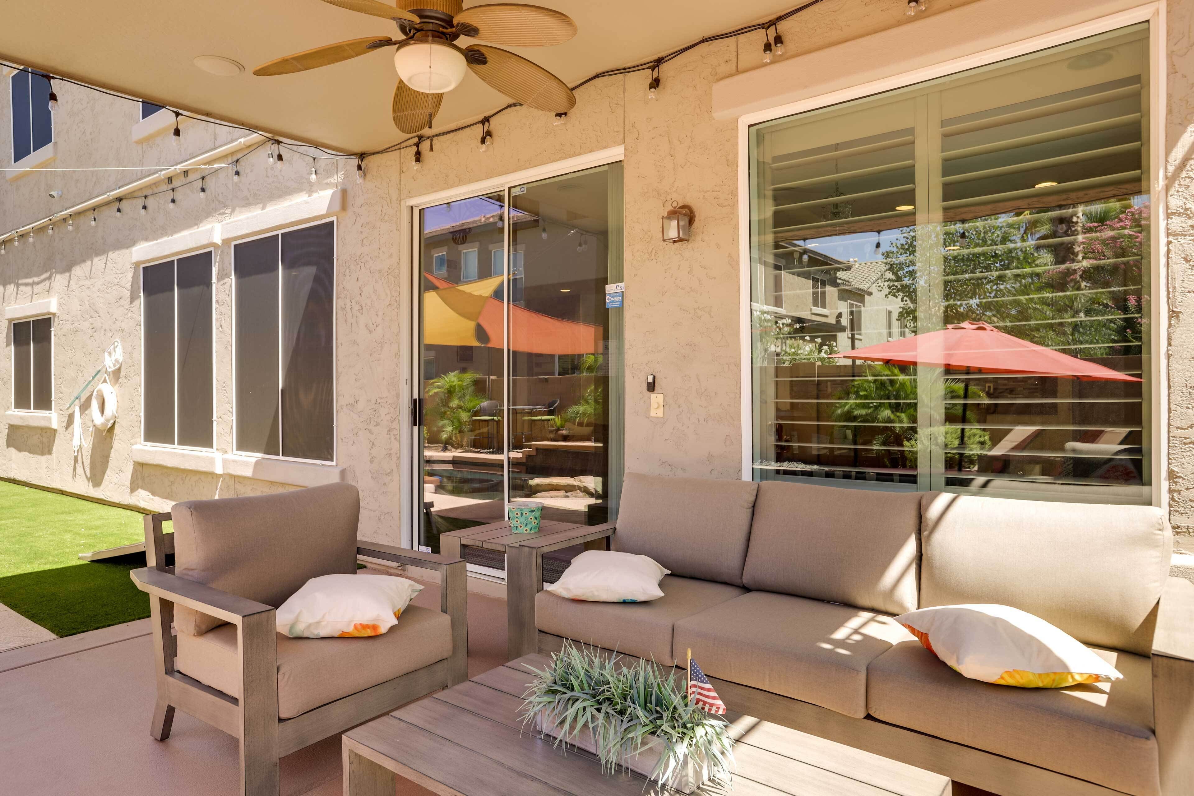 An outdoor patio area with a sofa, chairs, and a small table.