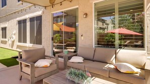 Un espace extérieur aménagé avec un canapé, des fauteuils et une petite table.