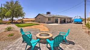 A house with a patio area featuring a fire pit and turquoise chairs. - Putting Green, Pool Access: Lake Havasu City Home! (Lake Havasu City)