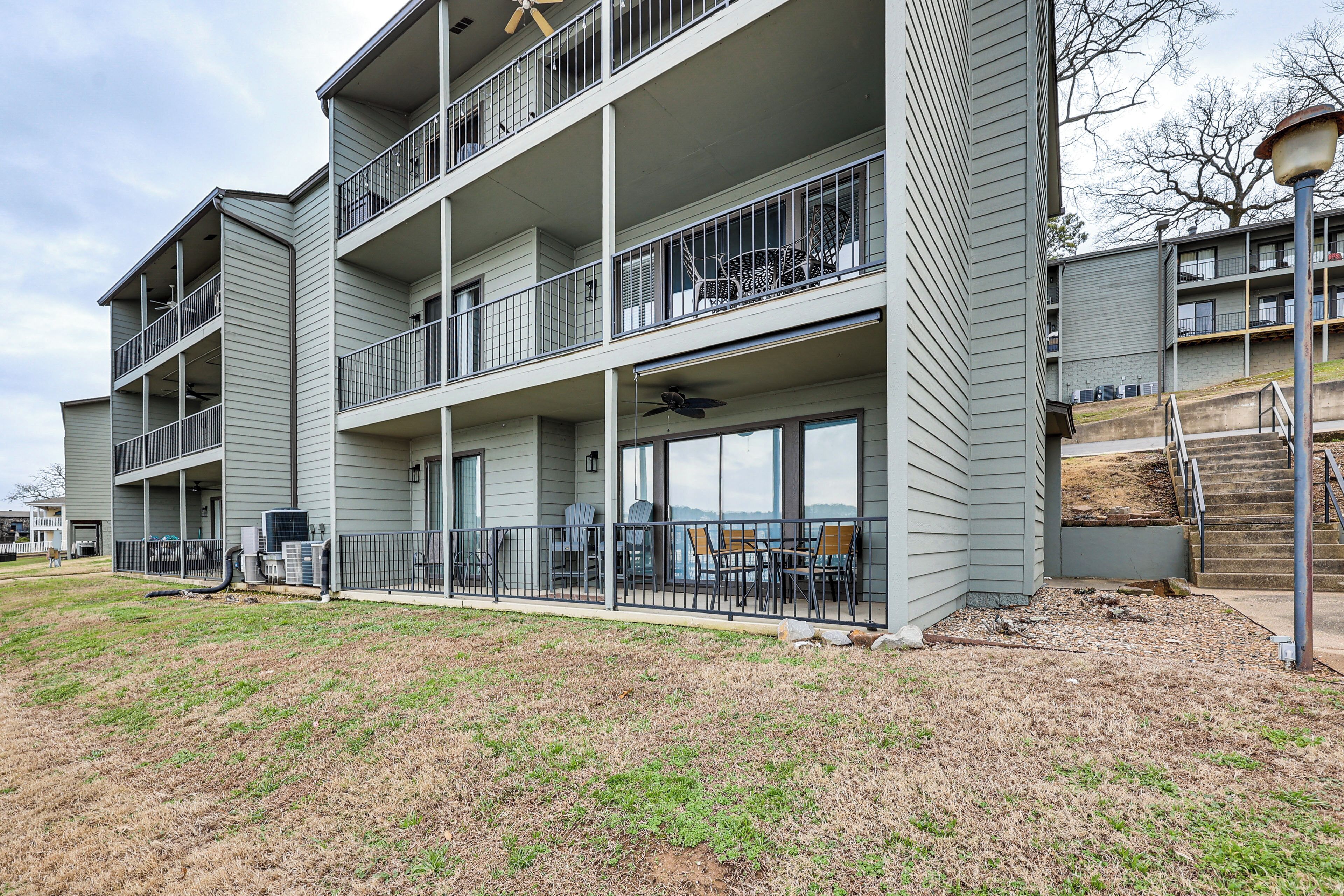A multi-story residential building with balconies, outdoor seating, and a covered patio area.