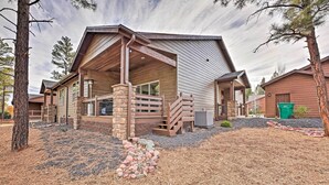 Un chalet doté d’un porche couvert, de piliers en pierre et d’une allée gravillonnée.