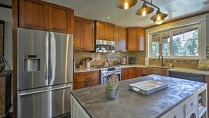 A modern kitchen with stainless steel appliances, wooden cabinets, and a large island with a built-in sink. - Home w/ Jacuzzi: 10 Mi to NAU & Flagstaff! (Flagstaff)