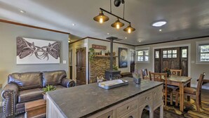 A modern kitchen with a central island, wooden cabinets, and a dining area with a wooden table and chairs. - Home w/ Jacuzzi: 10 Mi to NAU & Flagstaff! (Flagstaff)