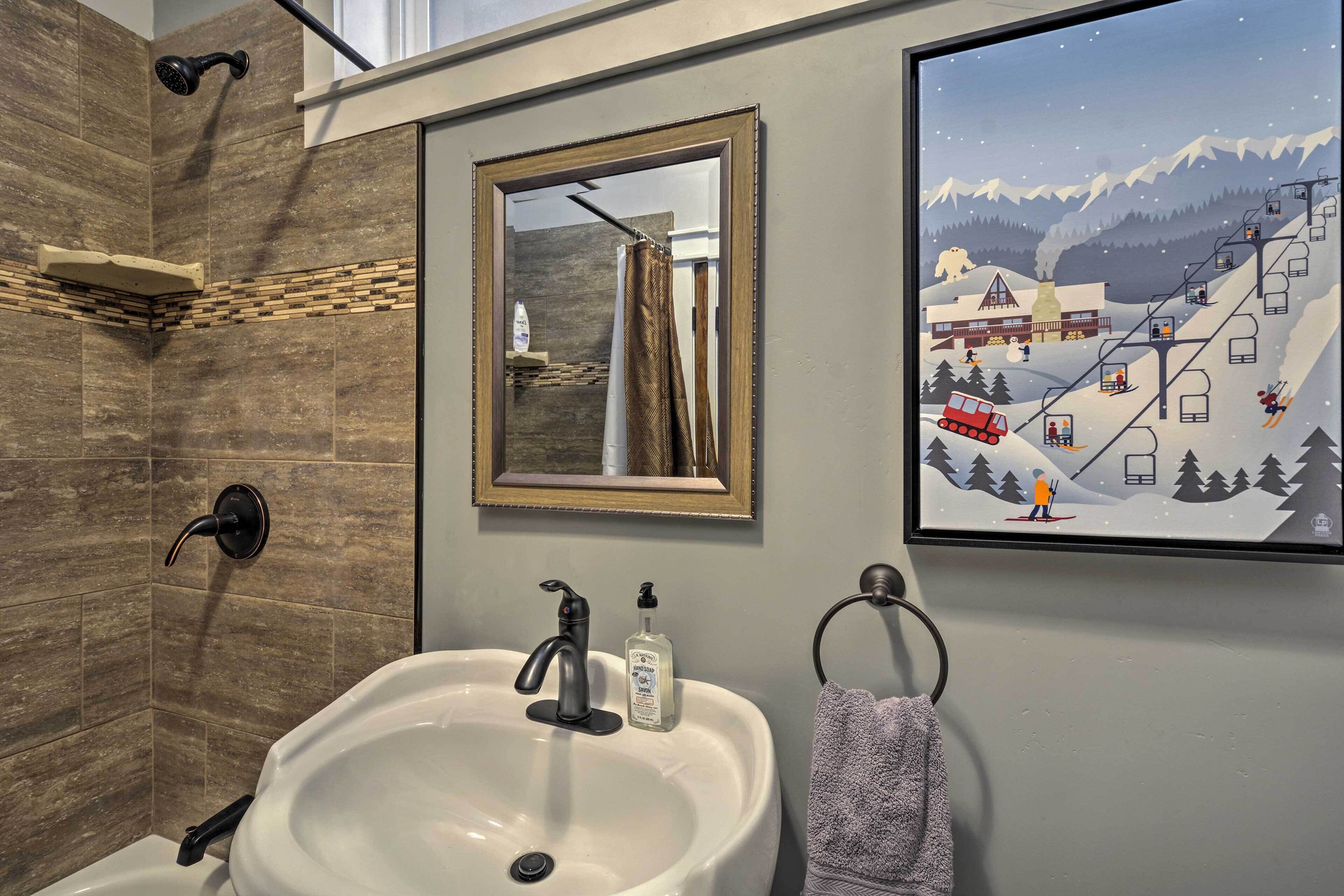 Un bagno con lavandino, specchio e doccia.