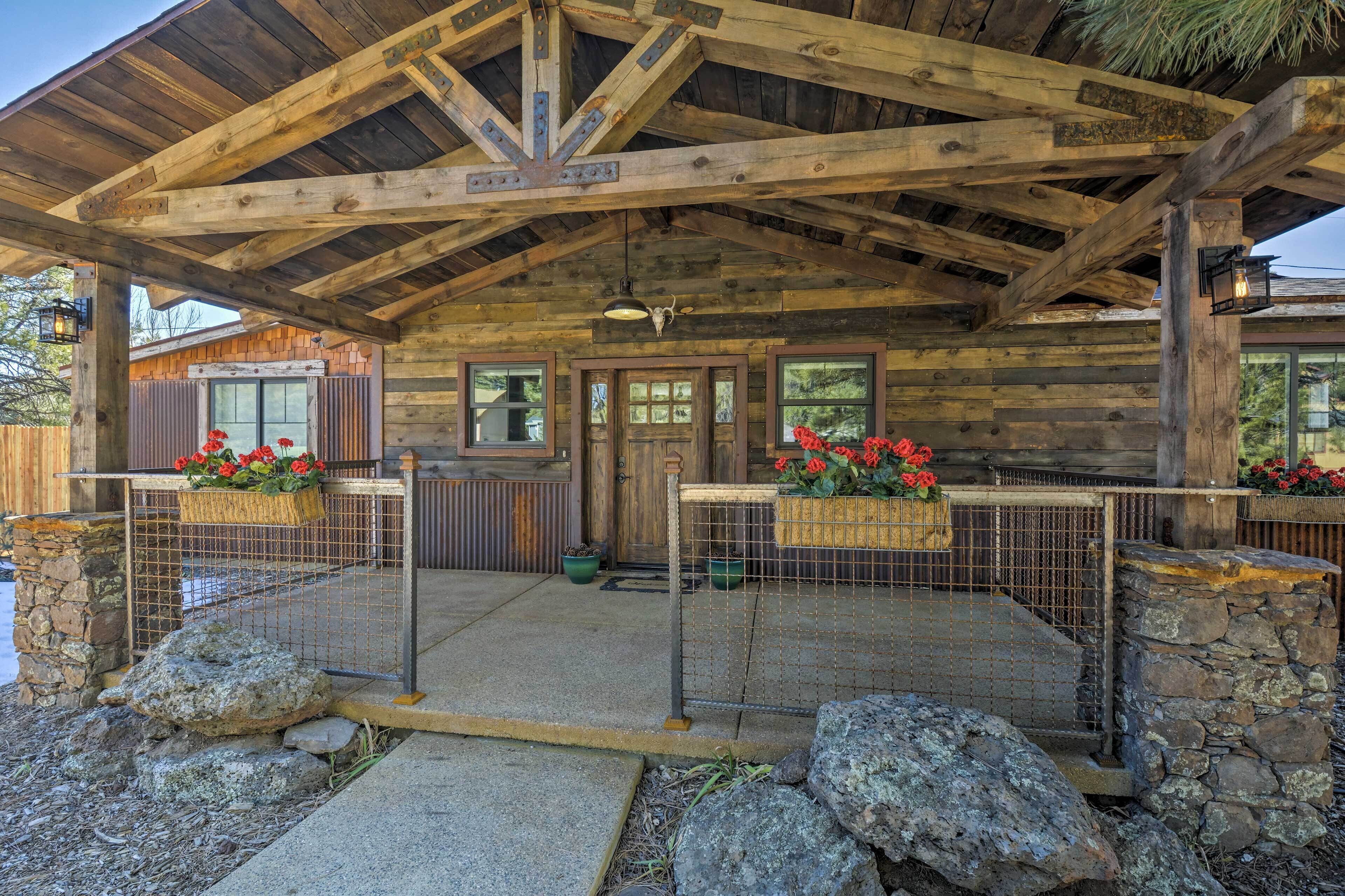 Eine rustikale Holzhütte mit Stein Fundament und einer Veranda mit Metallgeländer.